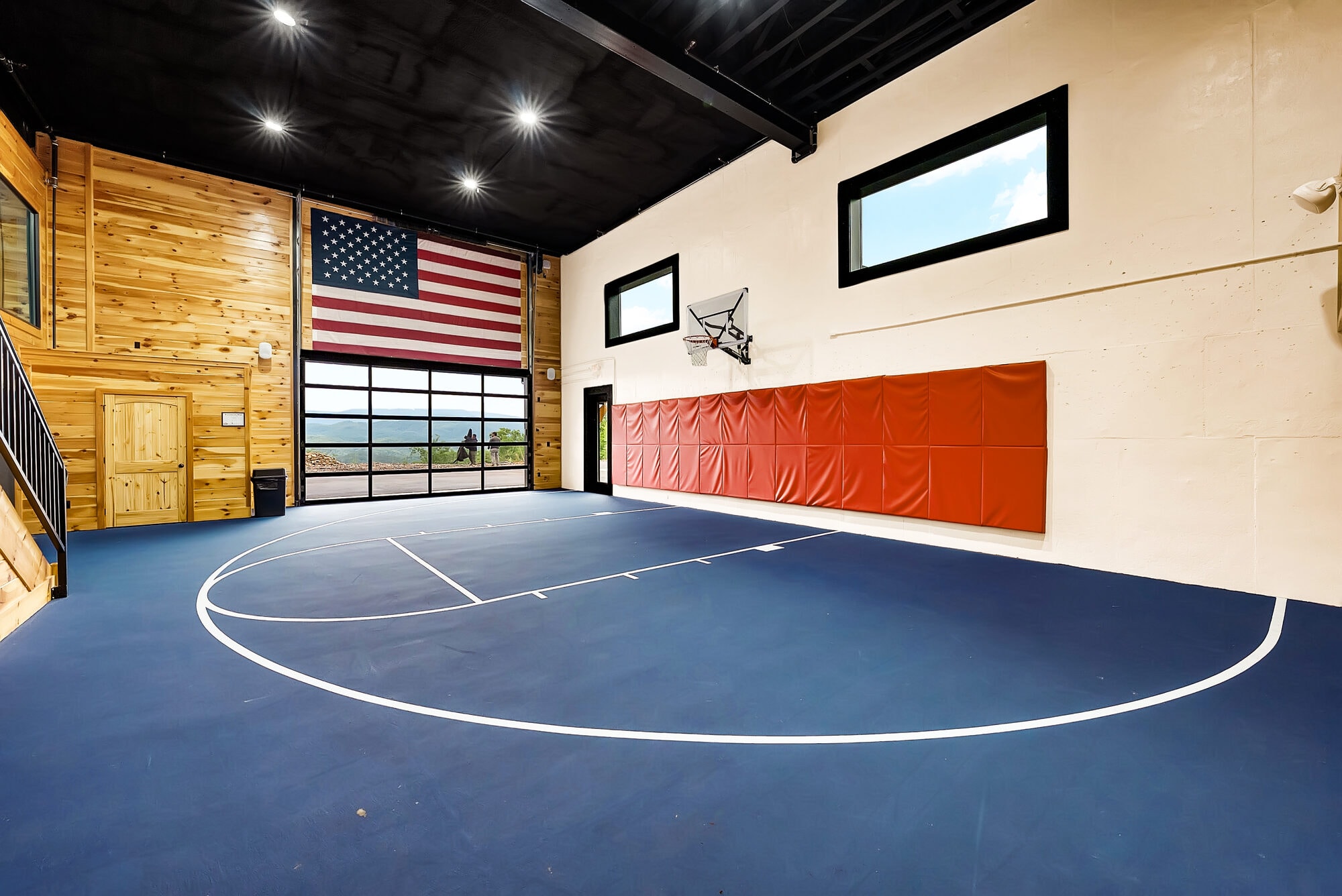 Excalibur private indoor basketball court with American flag, luxury lodge