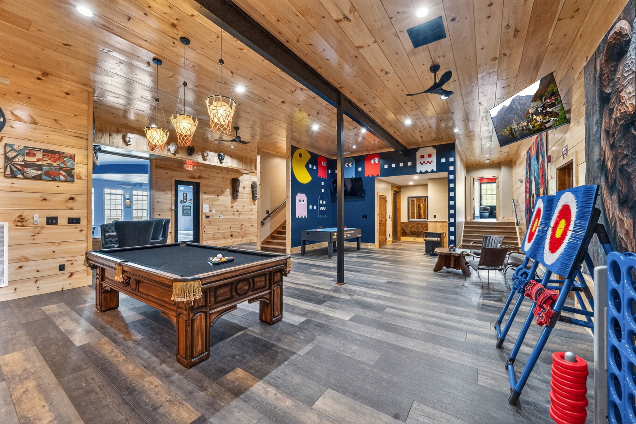 Excalibur game room with Pac-Man mural and arcade games, luxury lodge