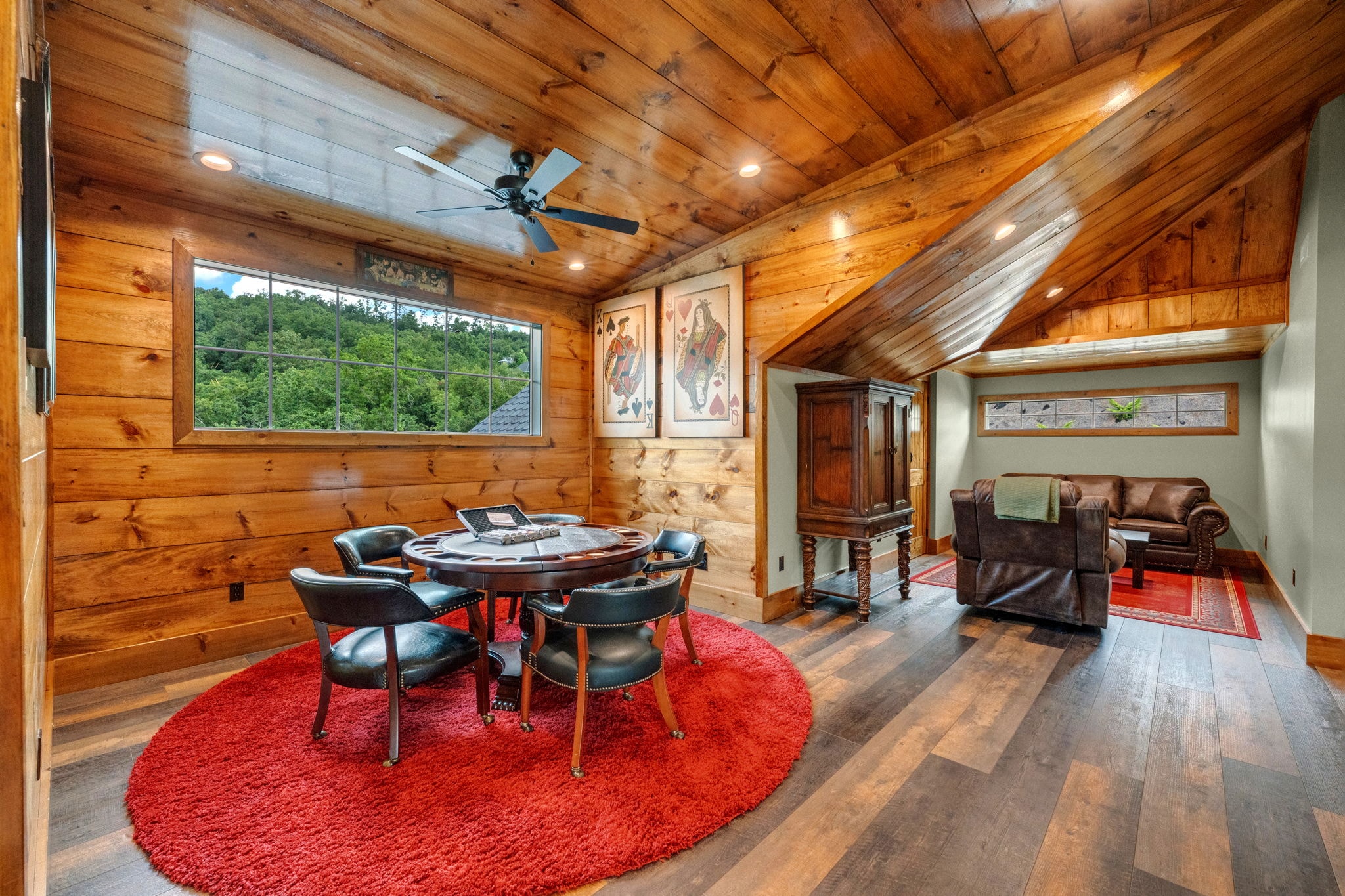 Excalibur poker room showing flat-screen TV, mountain sunset painting, and balcony beyond