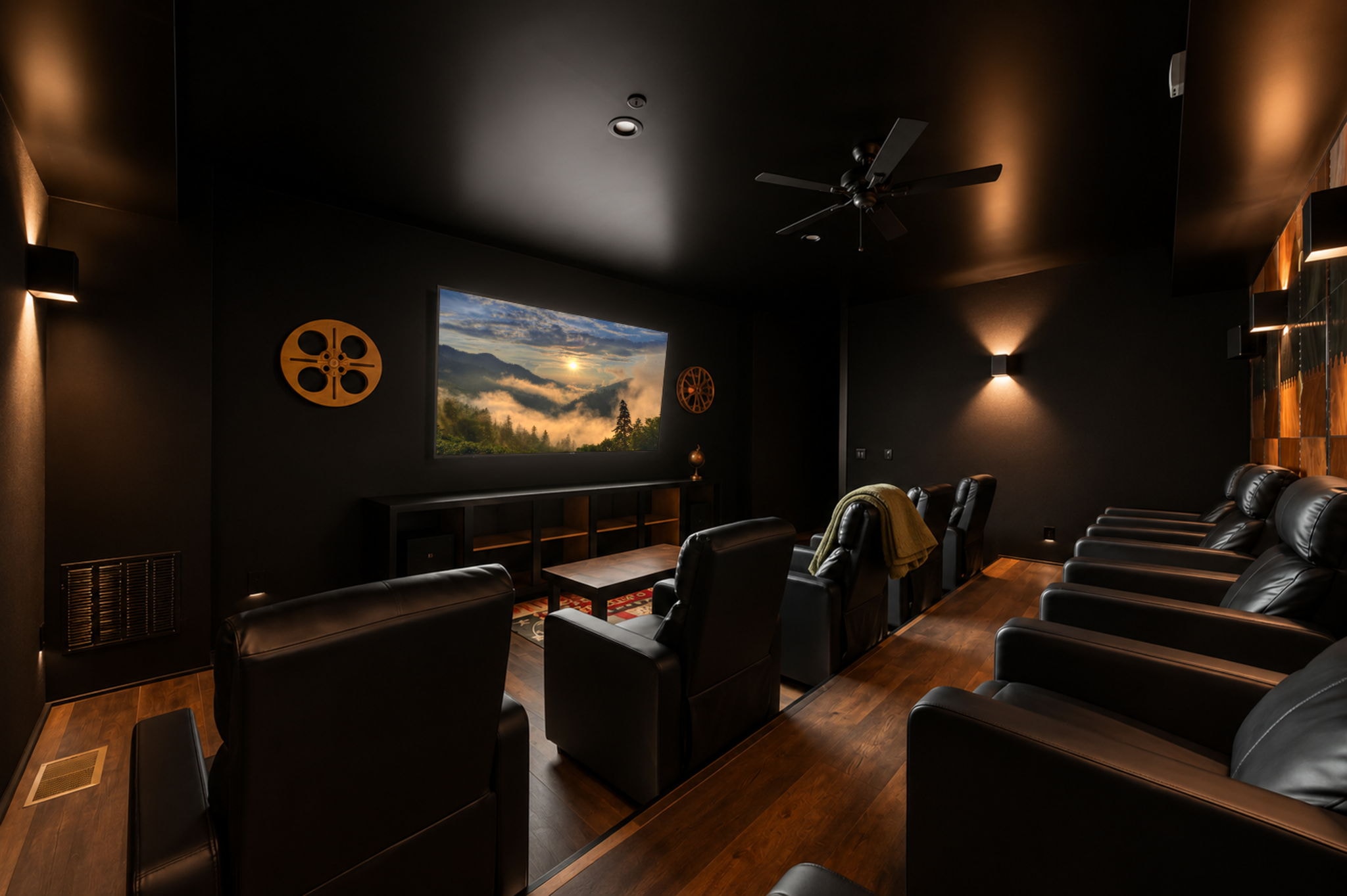 Modern soundproof home theater room with black leather recliners and 100-inch screen
