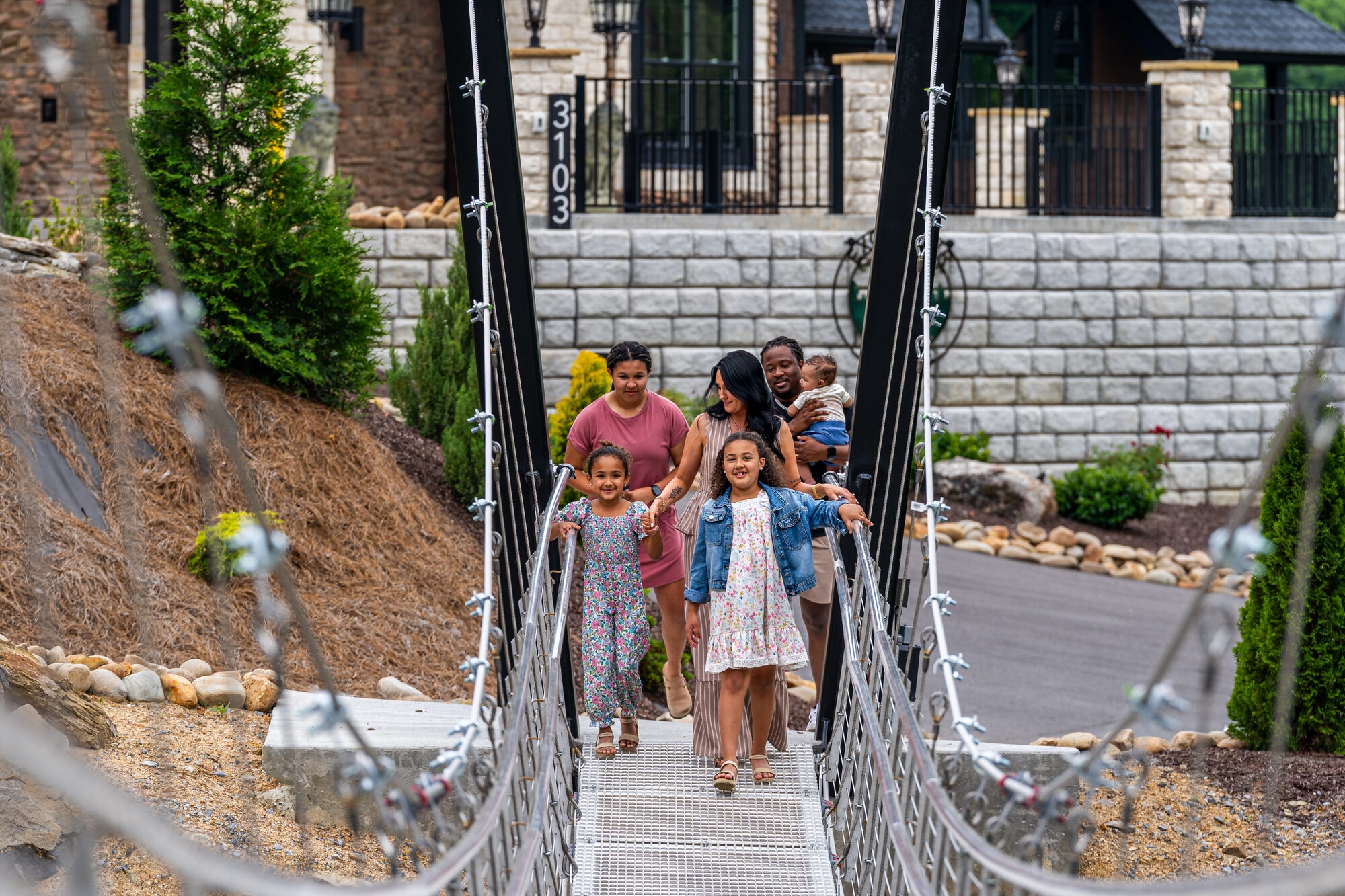 Family crossing the 100-ft custom swinging skybridge at Excalibur Lodge Smoky Mountains