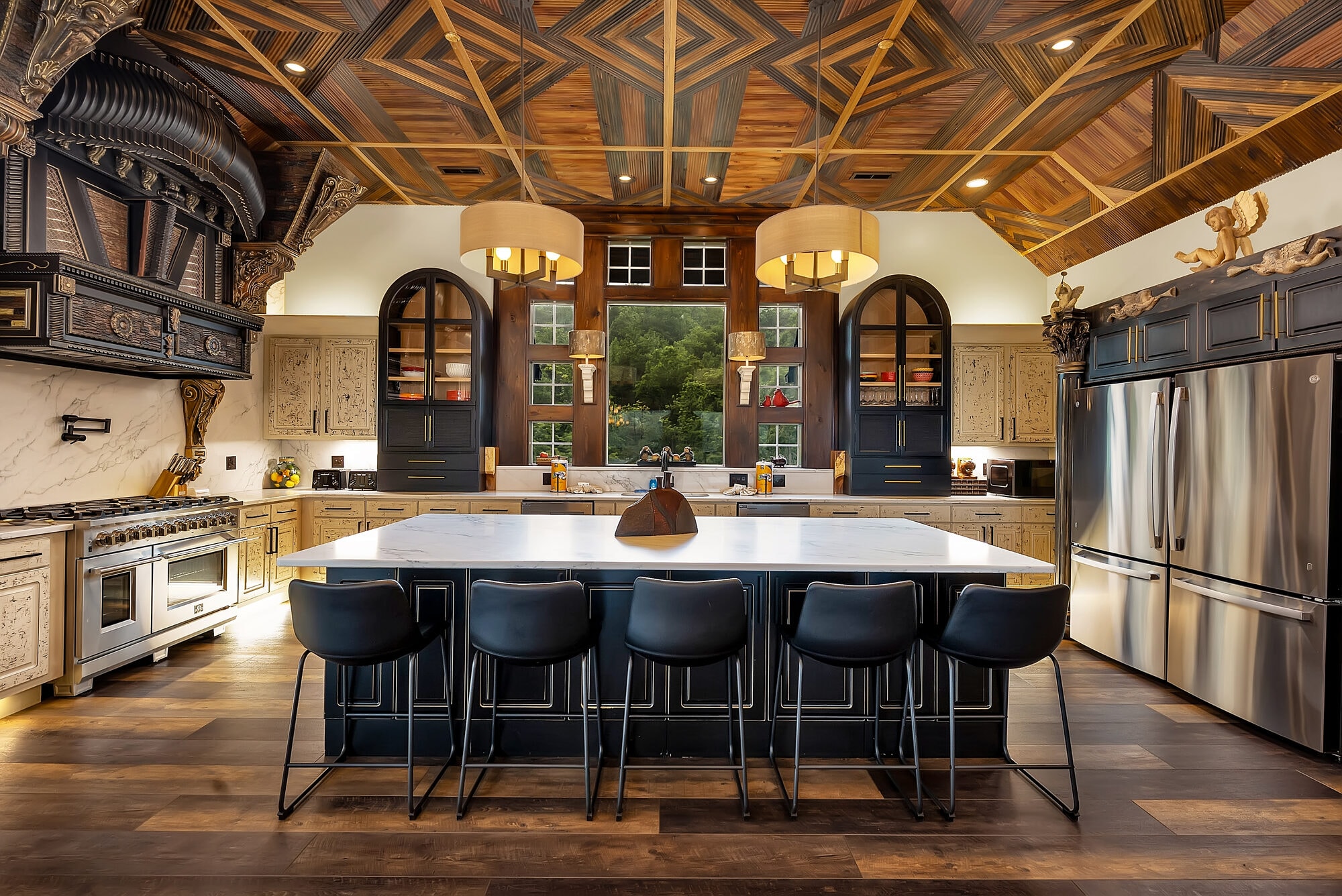 Excalibur gourmet kitchen — 6-burner gas range, marble island, arched cabinetry, geometric wood ceiling